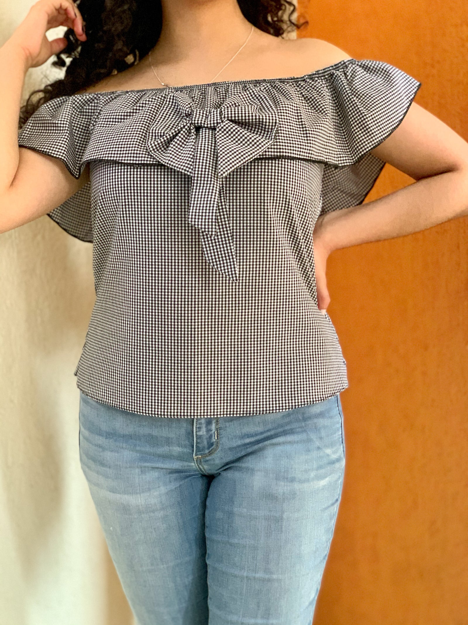 Blusa campesina con moño al frente en tela de cuadros.