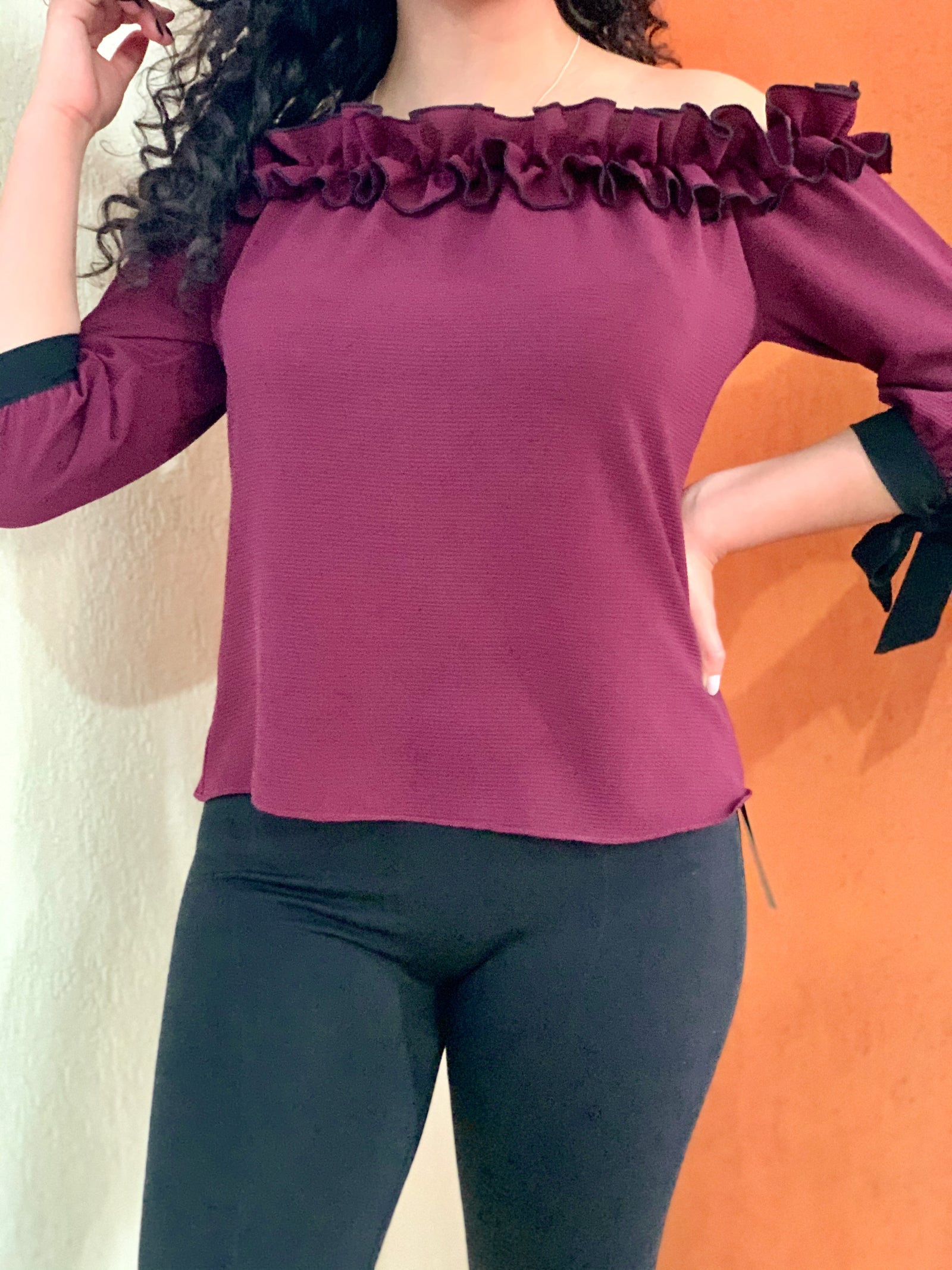 Blusa a los hombros con holán y cintas en las muñecas color vino.