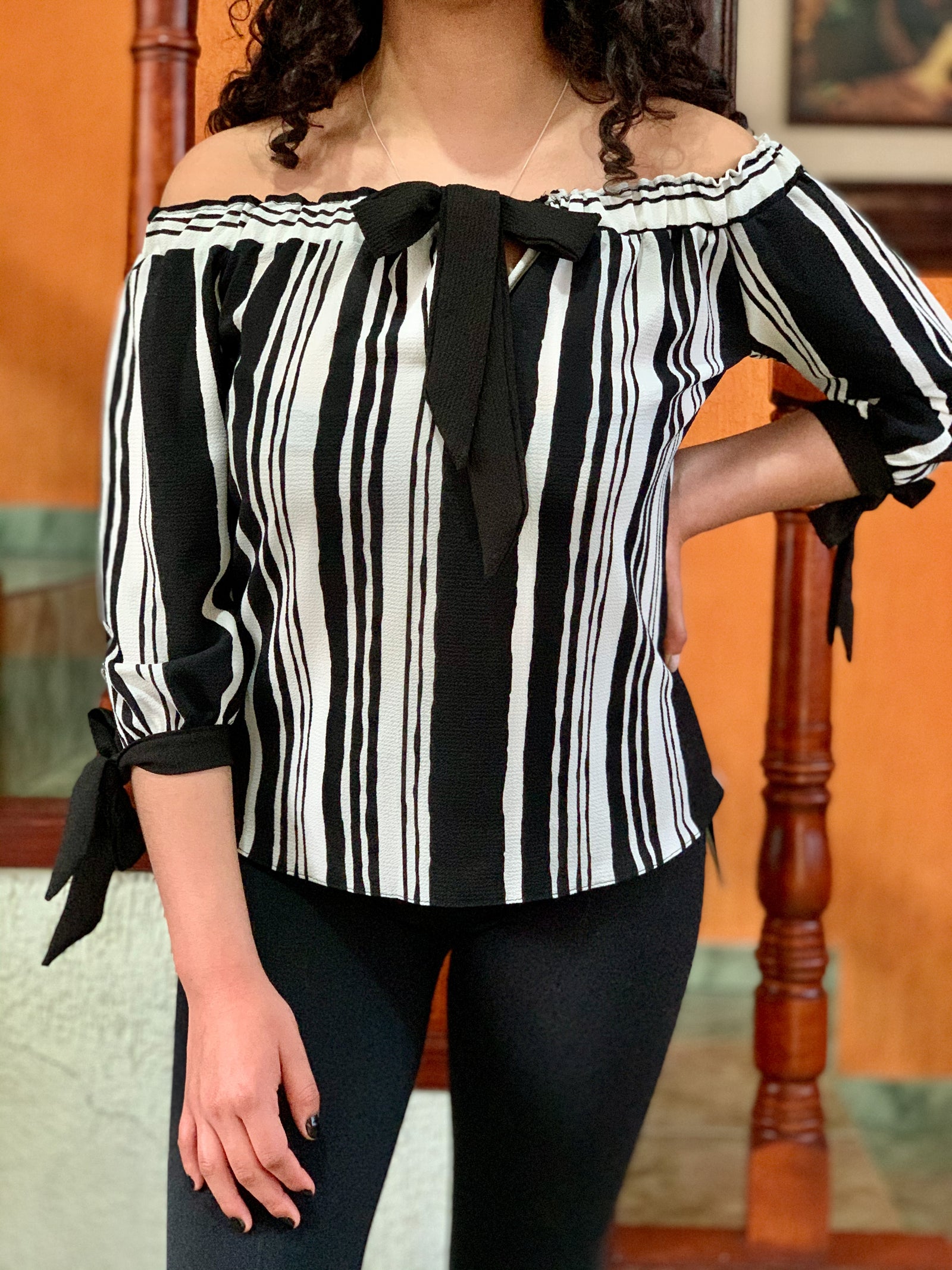 Blusa campesina rayada con corbatín y cintas en las muñecas.