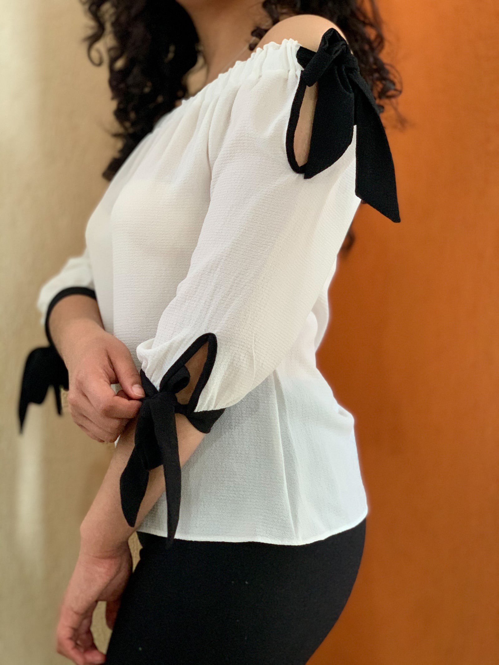 Blusa a los hombros color blanca con detalles en negro.