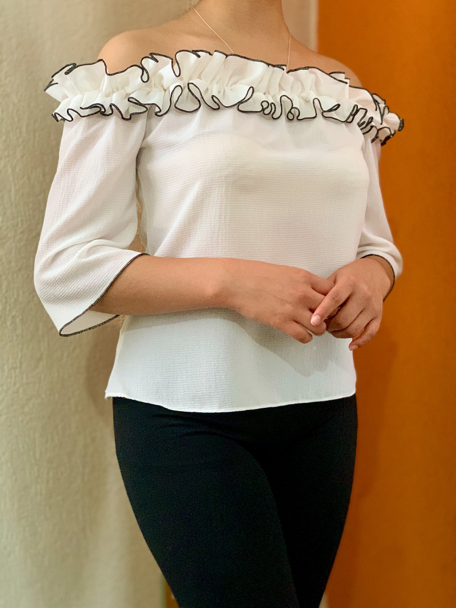 Blusa blanca con acabado en festón negro.