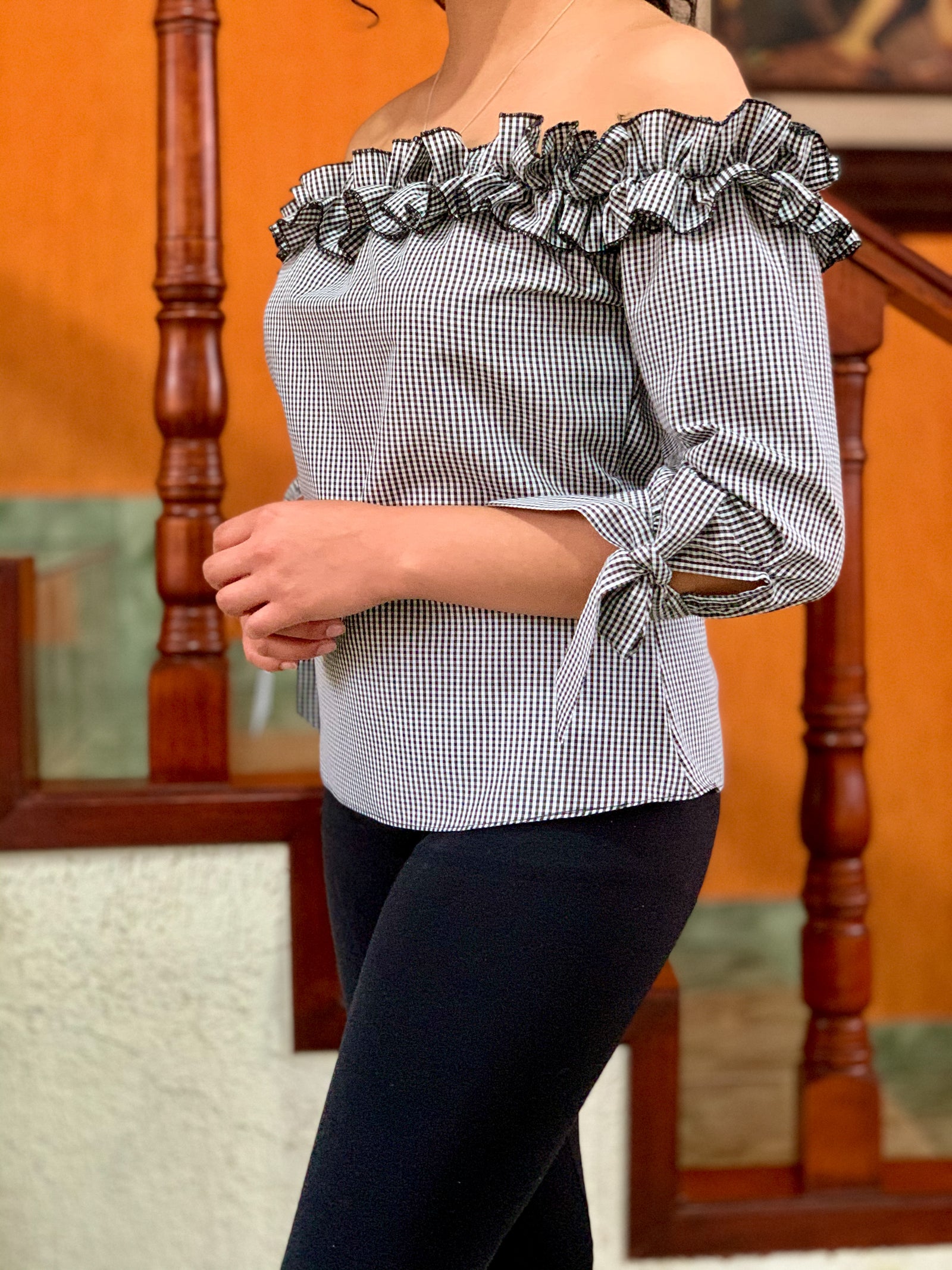 Blusa a los hombros con holán y cintas en las muñecas en tela de cuadros.
