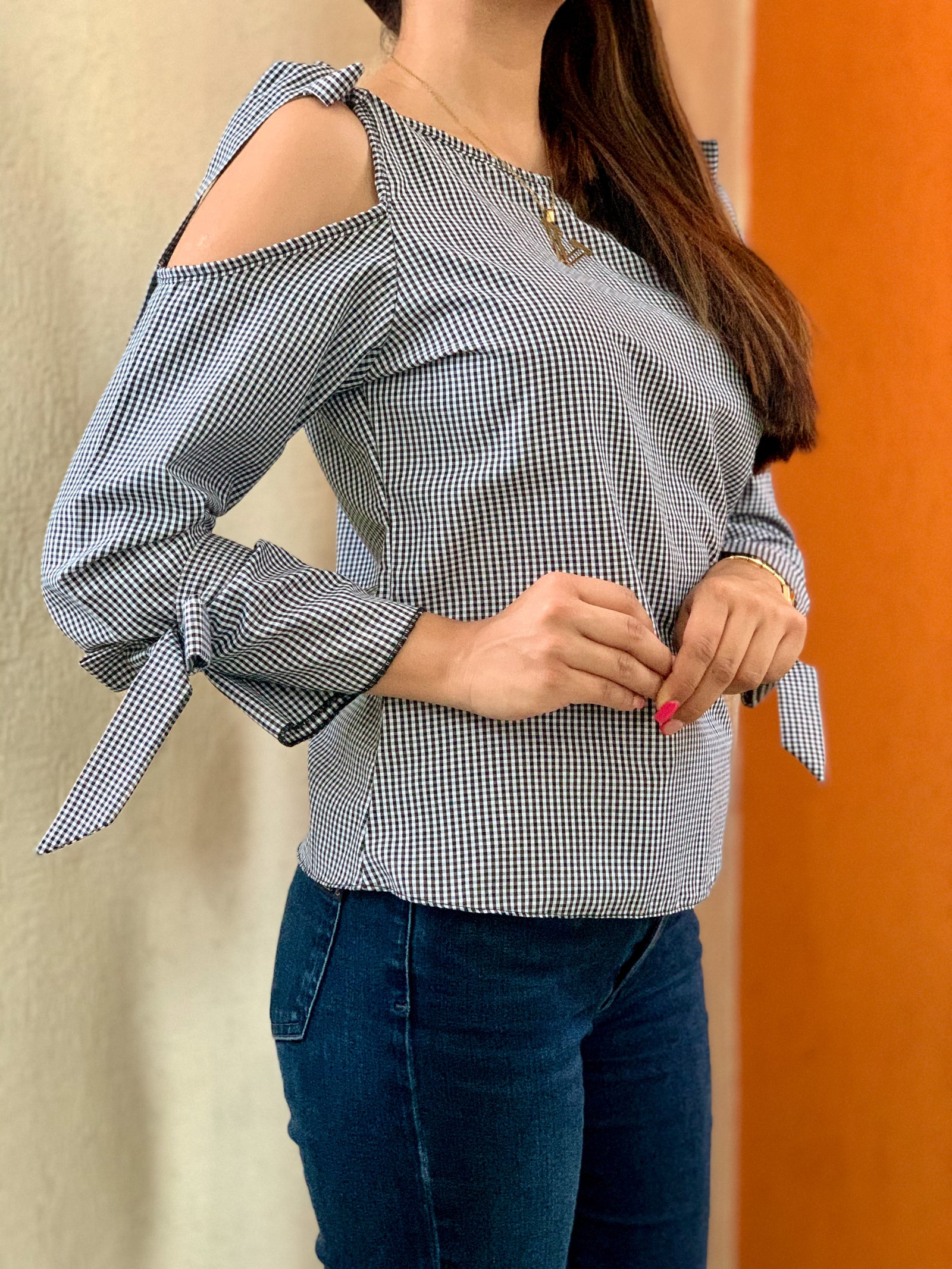 Blusa de cuadros con tiras en los hombros y en las muñecas para amarrar.