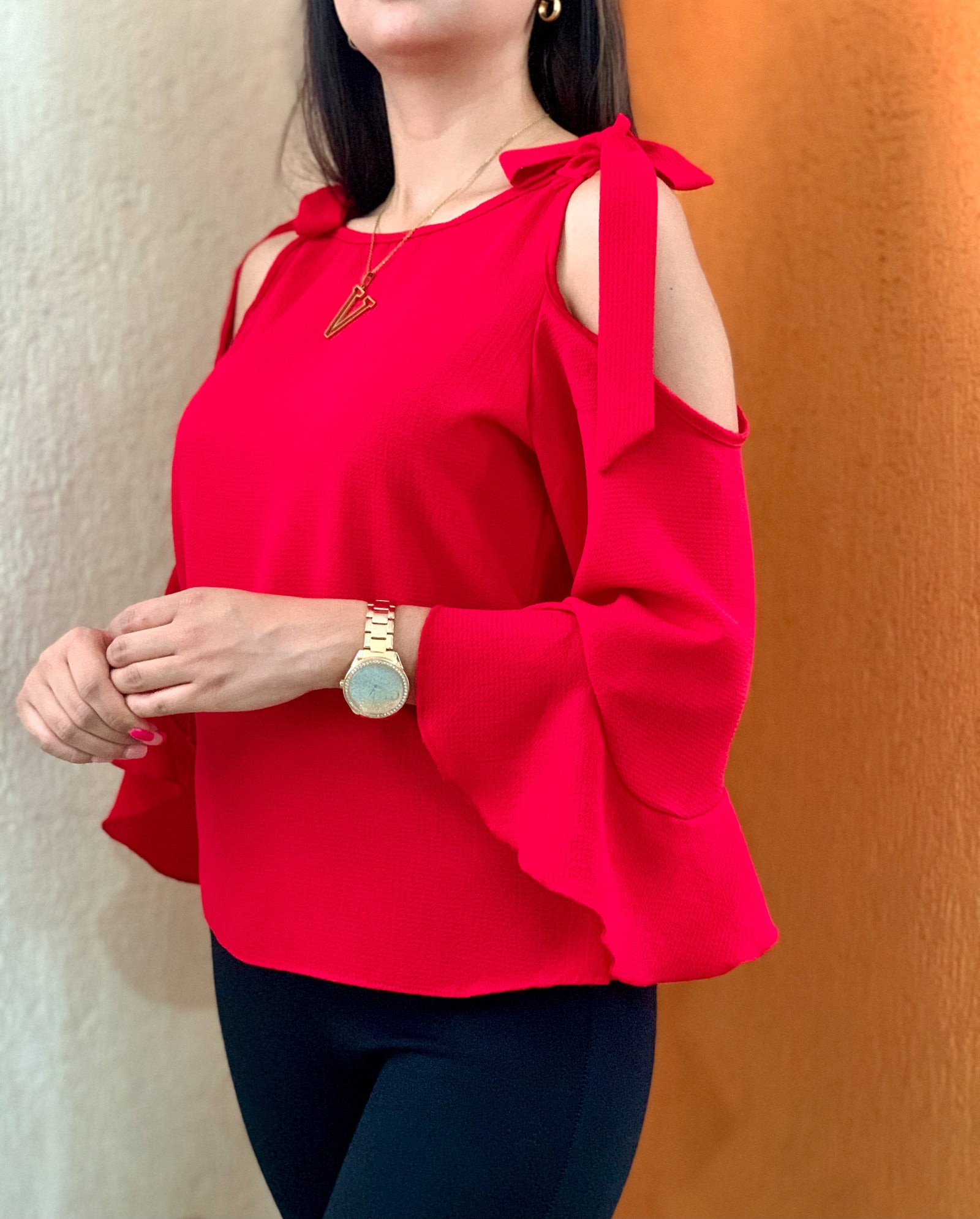 Blusa color rojo con manga de campana y tiras para amarrar.