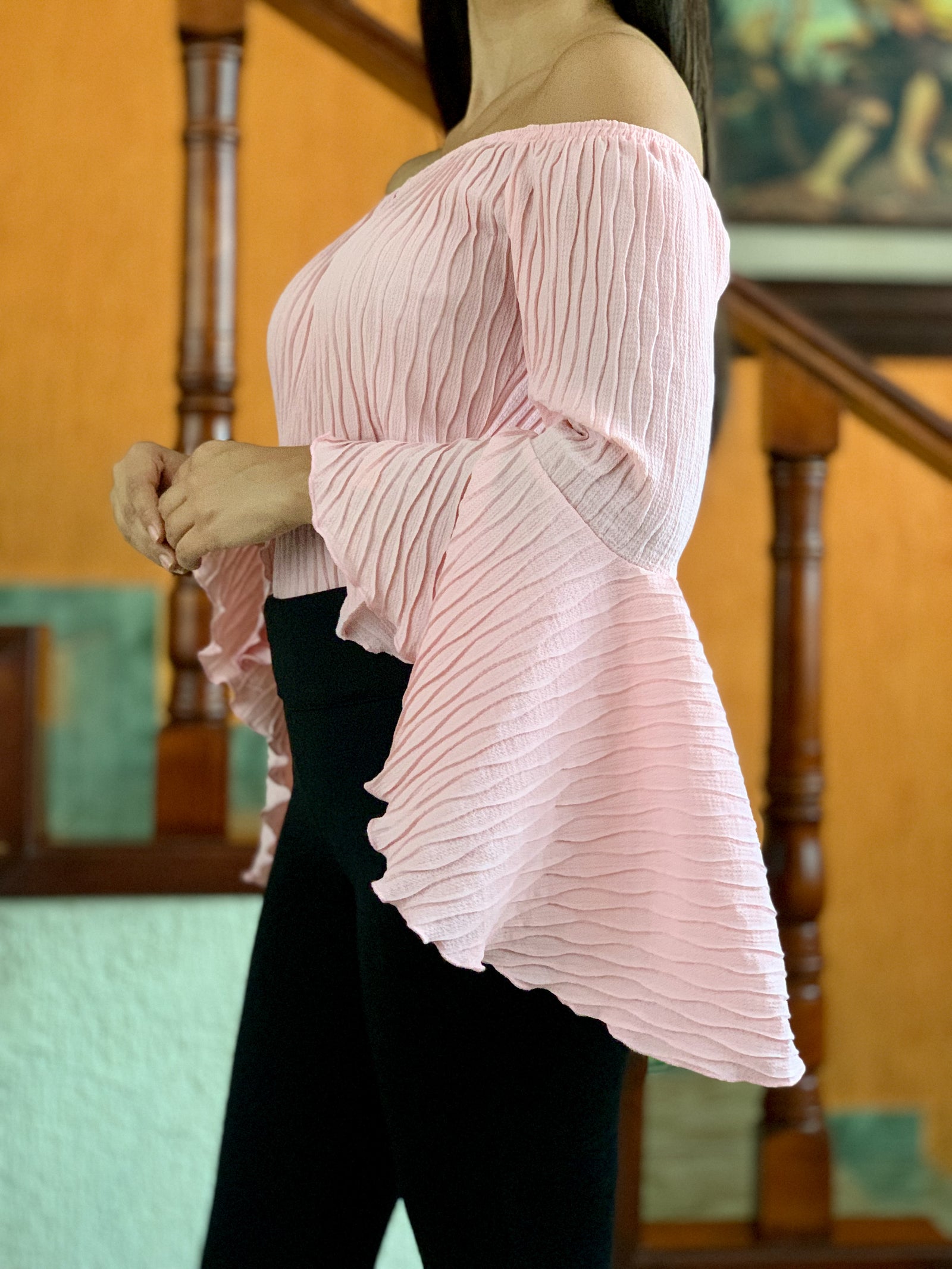 Blusa rosa con manga de holanes en tela con textura y acabado en festón.